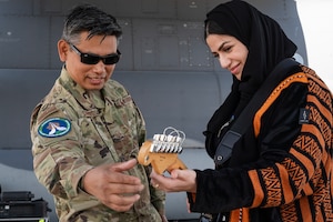 Two people look at a guitar.