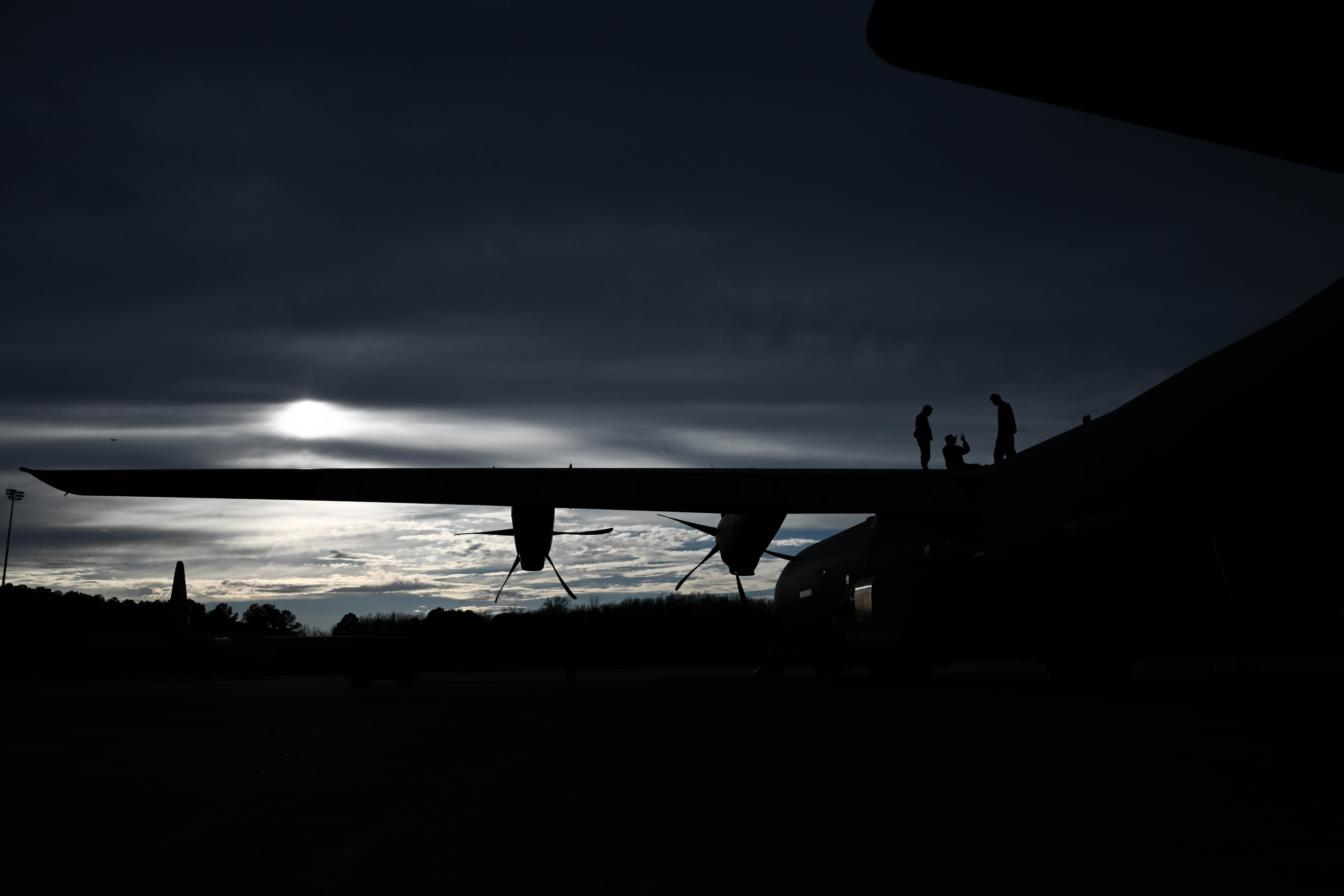 Airmen assigned to the 19th Aircraft Maintenance Squadron stand on the wing of a C-130J Super Hercules