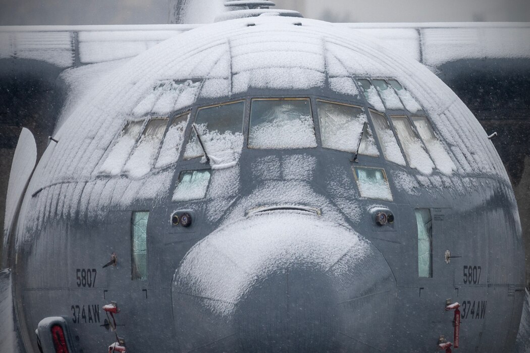 A U.S. Air Force C-130J Super Hercules assigned to the 36th Airlift Squadron sits in the snow on the flightline