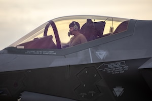 A photo of an F-35 maintainer performing an engine run in the cockpit