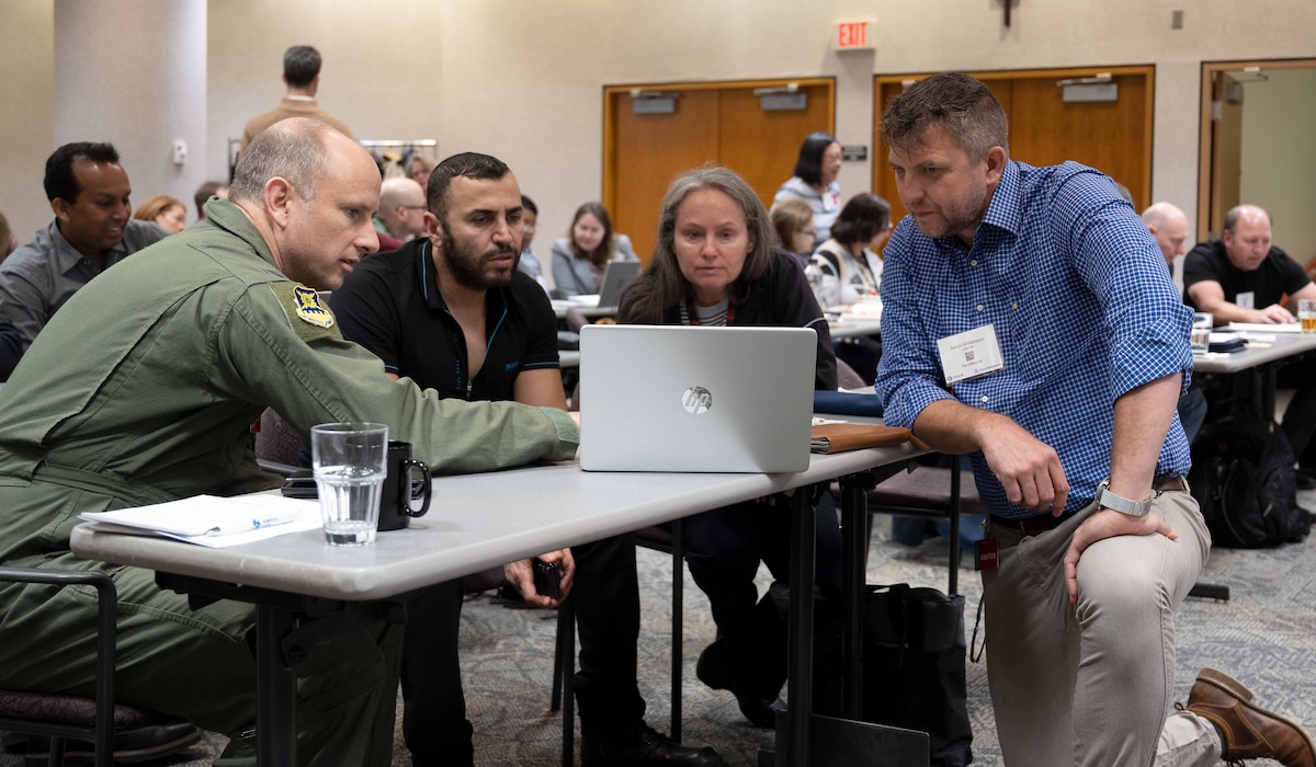 An AI training facilitator observes a group exercise.