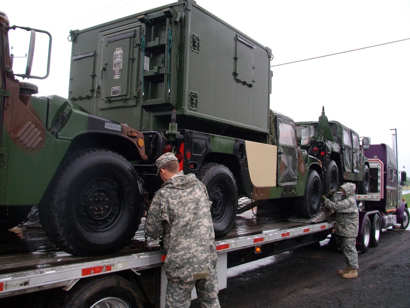 Soldiers of the 116th Infantry Brigade Combat Team, Virginia Army National Guard unload vehicles from a tractor trailer May 30, 2015, at Fort Drum, NY. T