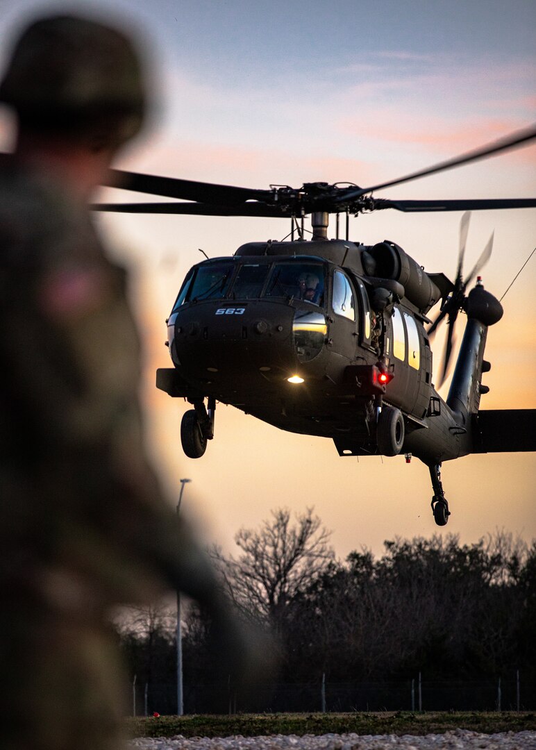 A Soldier with Echo Company, 1st Battalion (Assault Helicopter Battalion), 244th Aviation Regiment, 90th Troop Command, Oklahoma Army National Guard watches a UH-60 Black Hawk helicopter take off at Fort Cavazos, Texas, Jan. 10, 2024. The 244th AHB underwent rigorous mobilization training in preparation for their upcoming deployment to Kosovo in support of Operation Joint Guardian. (Oklahoma National Guard photo by Cpl. Danielle Rayon)