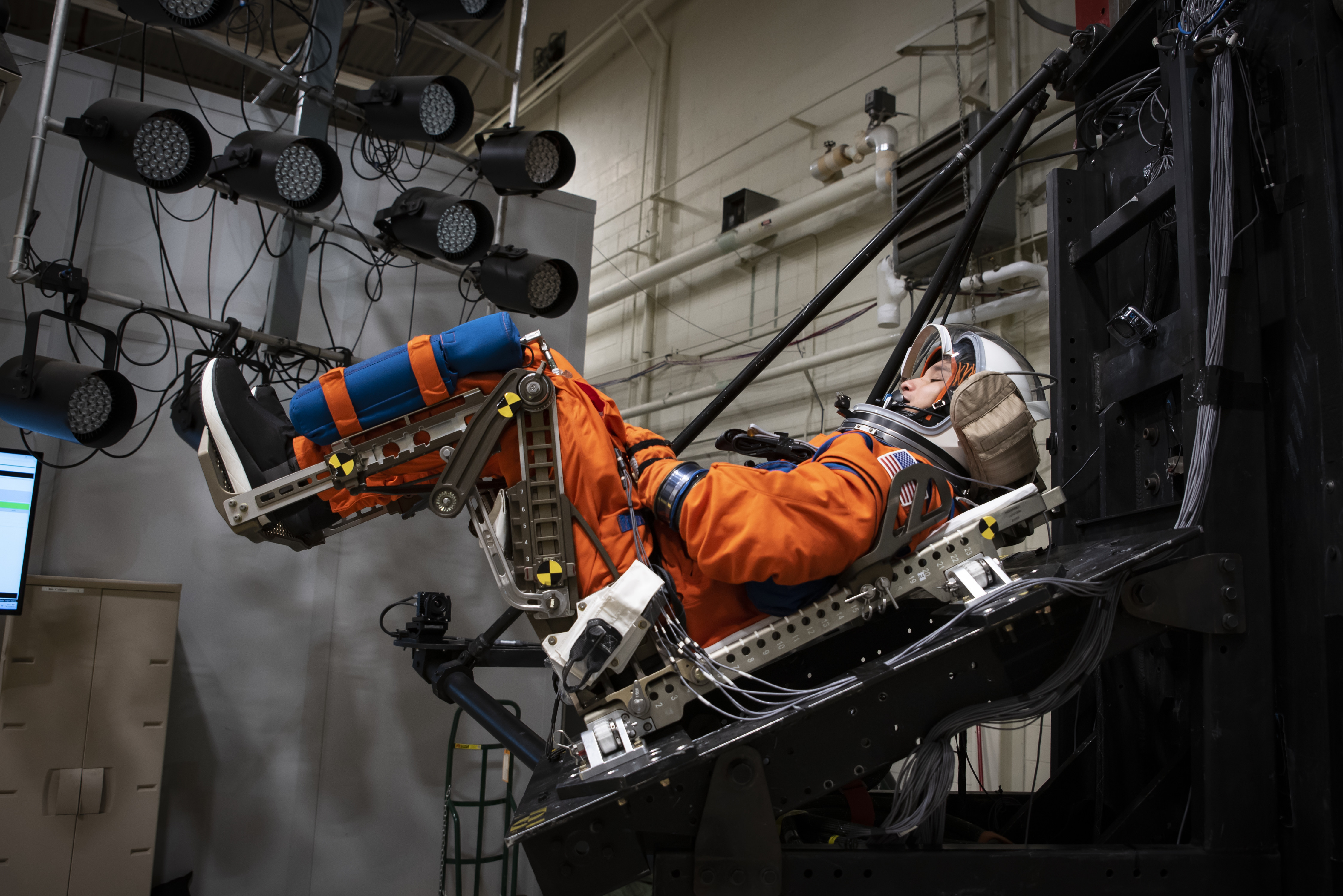 A U.S. Air Force volunteer tests the next replica of a flight suit and seat for the Orion space capsule in the drop tower facility at Wright-Patterson Air Force Base, Ohio, Nov. 3, 2023. Researchers with the Air Force Research Laboratory’s Human Effectiveness Directorate tested equipment along with NASA for the Orion space capsule’s upcoming mission to the moon. (U.S. Air Force photo / Richard Eldridge)