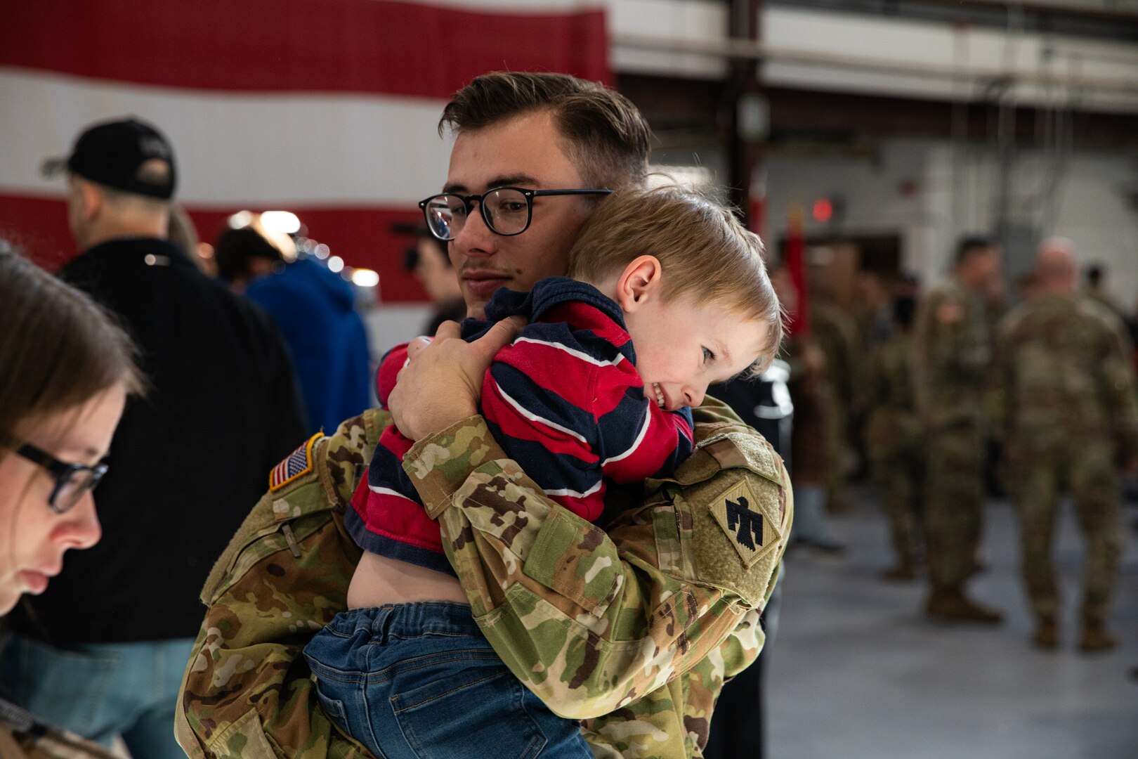 Loved ones gather alongside nearly 50 Oklahoma Army National Guardsmen during a deployment ceremony held Saturday, Dec. 30, 2023, at the Army Aviation Support Facility 2 in Tulsa, Oklahoma. Members of Charlie Company, 1st Battalion (Assault Helicopter Battalion), 244th Aviation Regiment, 90th Troop Command, will deploy overseas to Kosovo in support of Operation Joint Guardian (KFOR). KFOR is a NATO-led international peacekeeping force in Kosovo that is comprised of 27 partner nations. (Oklahoma National Guard photo by Staff Sgt. Reece Heck)