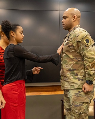 Col. Jason Carter is pinned with his new rank by his daughter, Cenea, during a promotion ceremony held at the Illinois National Guard’s Military Academy in Springfield, Illinois.