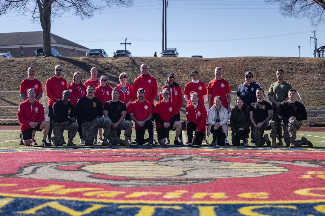 U.S. Marines with the Wounded Warrior Regiment and Federal Bureau of Investigation National Academy staff pose for a photo after an annual joint physical training and morale building event at Butler Stadium on Marine Corps Base Quantico, Virginia, Feb. 7, 2024. The FBI National Academy is a program that trains active U.S. and international law enforcement personnel. The event is an annual requirement for students and serves to strengthen the FBI and Marine Corps bond. (U.S. Marine Corps photo by Lance Cpl. Joaquin Dela Torre)