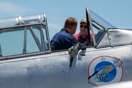Retired Col. Robert Prater, a former 137th Special Operations Wing Guardsman, shows 137th SOW Command Chief Master Sgt. Lawrence DeSalle, left, his T-6G Texan aircraft at the Tinker Air Show on July 1, 2023, at Tinker Air Force Base, Oklahoma City. Prater has been flying World War II-style aircraft for over 20 years and shares military history with future generations. (U.S. Air National Guard photo by Airman 1st Class Erika Chapa)