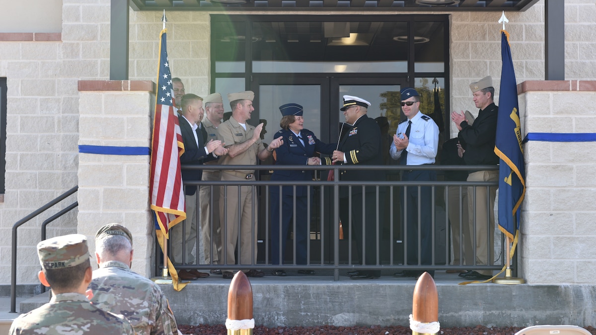 U.S. Air Force Col. Angelina Maguinness, 17th Training Wing Commander, and U.S. Navy Lt. Cmdr. Nicholas Leyba Center for Information Warfare Training Command Monterey, Detachment Goodfellow Headquarters commander shake hands upon completion of the Navy Ribbon Cutting Ceremony at Goodfellow Air Force Base Feb. 2, 2024. Due to a cold front in the winter of 2021, the original building was out of code and needed renovation; it was soon demolished. They renovated another building and decided to add a wing, which is now the headquarters quarterdeck/entryway, training room, gym, and additional office space. (U.S. Air Force photo by 2nd Lt. Kayunna Holt)