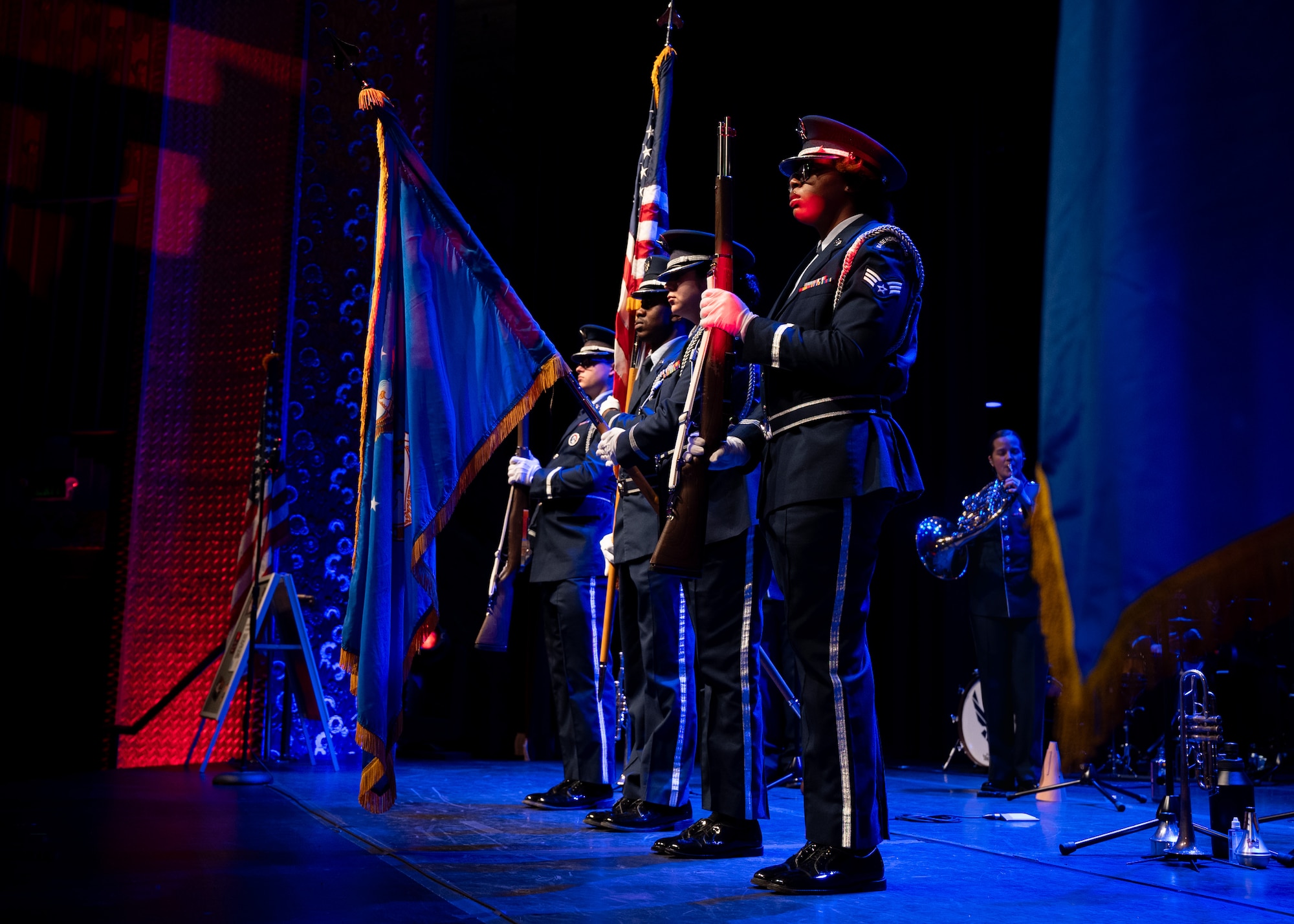 Four honor guardsmen present the colors on stage