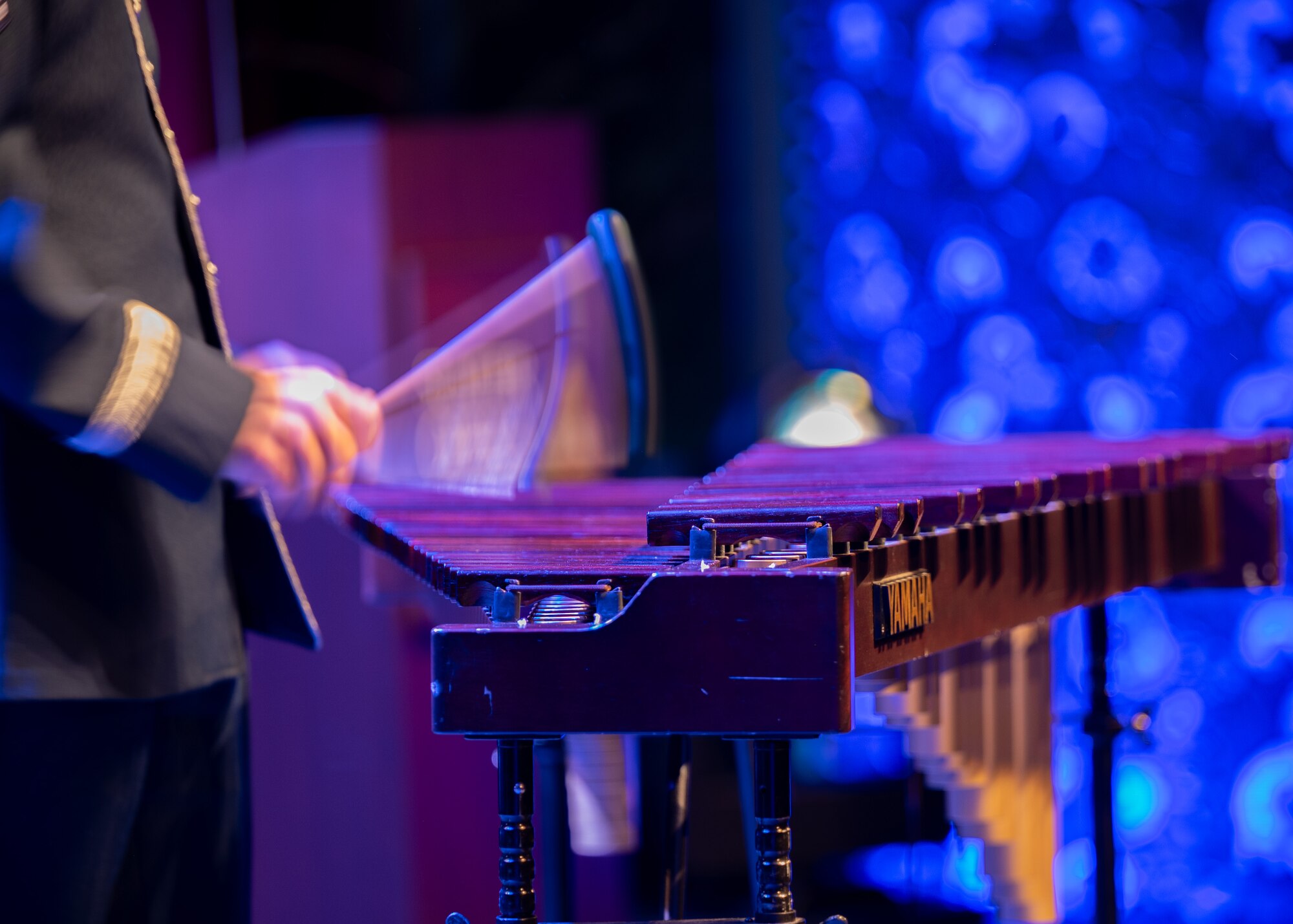 Airman plays xylophone on stage