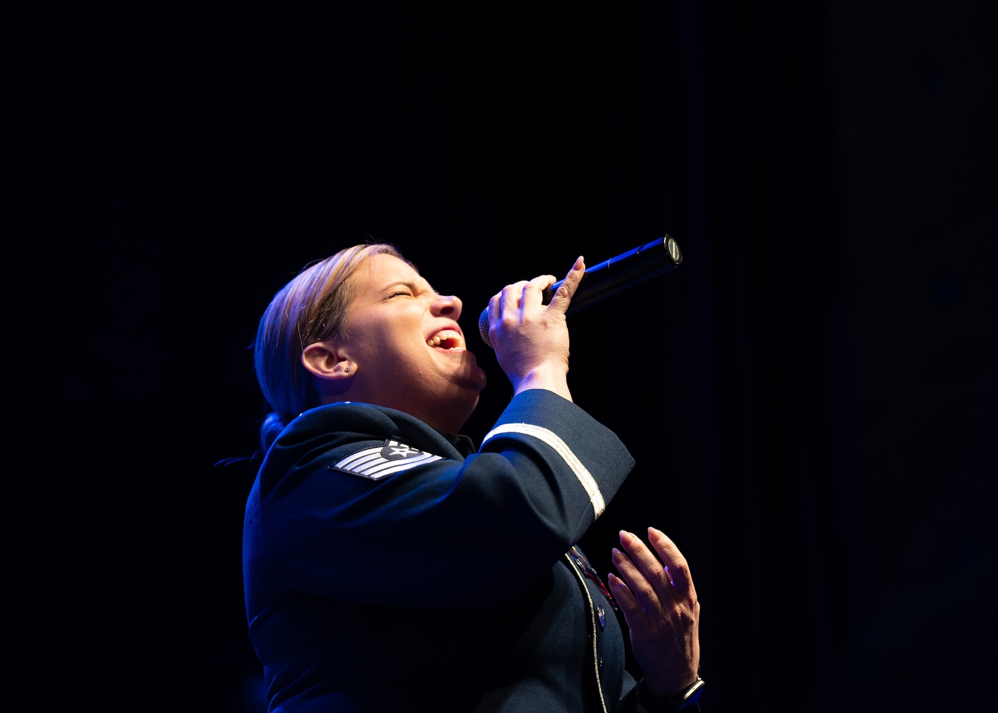 Airman sings on stage