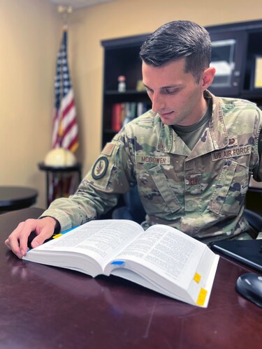 An Air Force lawyer is reviewing passages in the manual for court martials book.