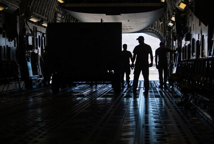 Airmen load cargo on a plane.