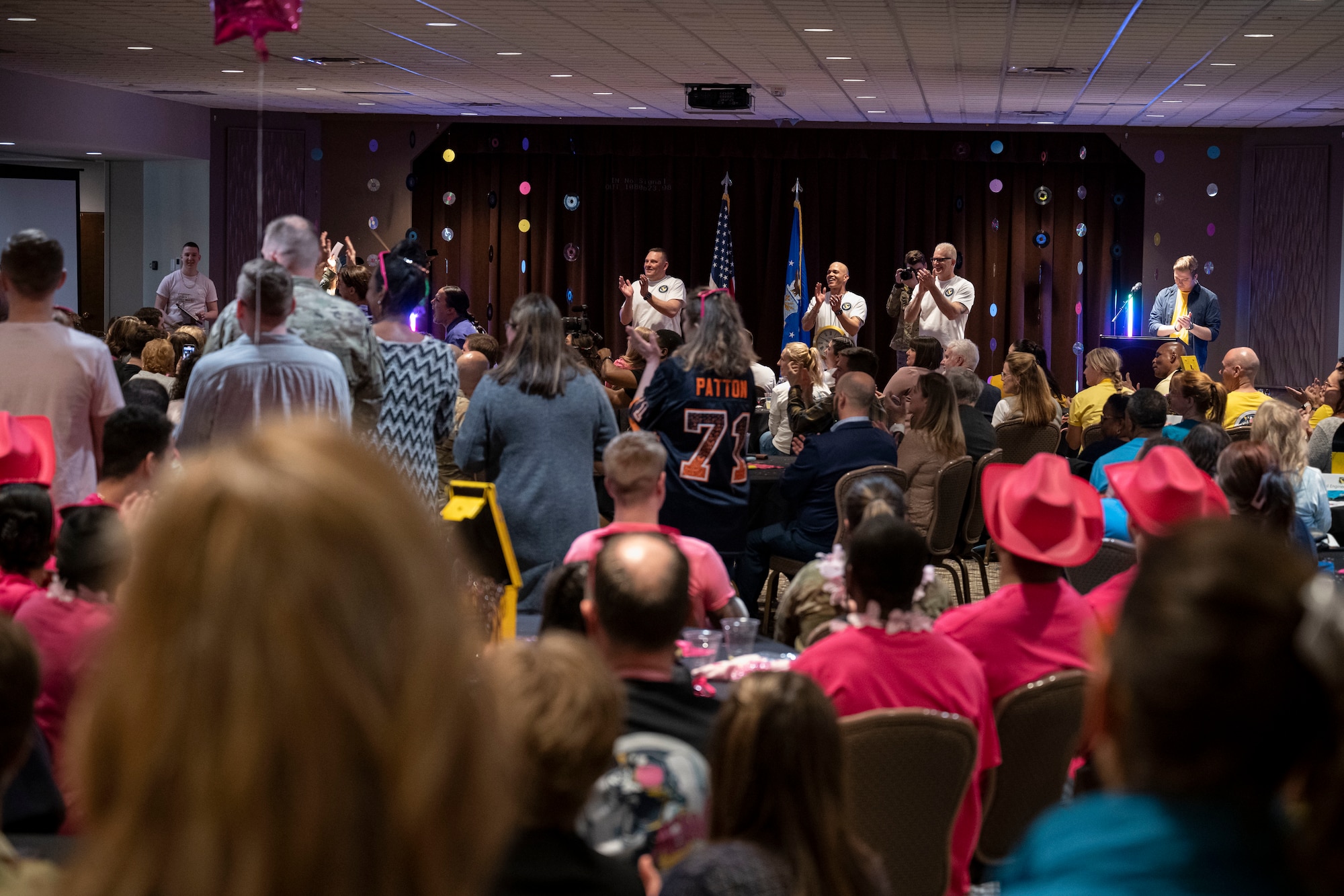 Event attendees celebrate in a crowded room.