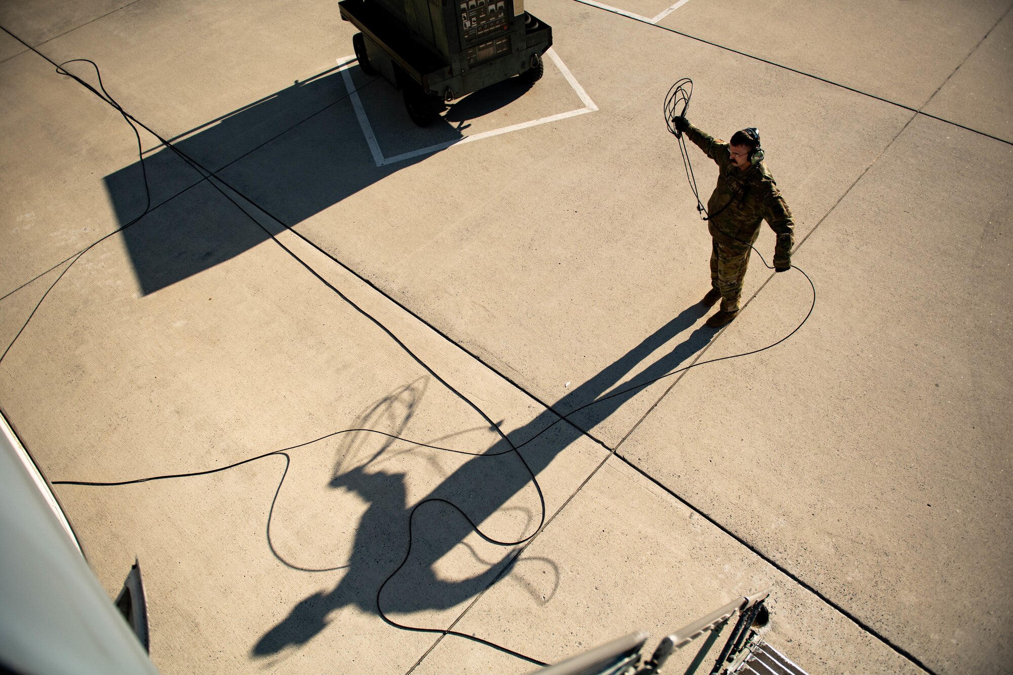 U.S. Air Force Staff Sgt. Broden McDonald, 9th Airlift Squadron flight engineer, straightens a communication cable from a C-5M Super Galaxy at Dover Air Force Base, Delaware, Feb. 7, 2024. The C-5M Super Galaxy was delivered to Westover Air Reserve Base, Massachusetts for an isochronal maintenance inspection. (U.S. Air Force photo by Tech. Sgt. J.D. Strong II)