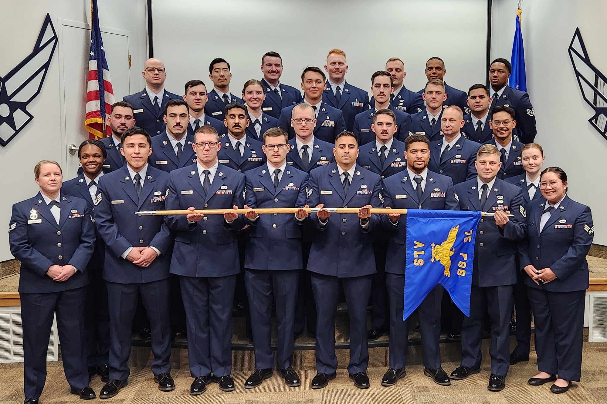 A group of airmen posed on risers in a shool photo setting