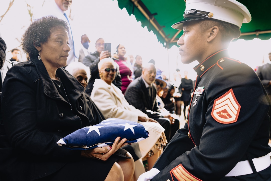 U.S. Marine Corps Staff Sgt. Deidra Freeman, an administrative chief with Inspector Instructor Frederick, presents the U.S. flag to Mary Chaney, the daughter of Pfc. John Henry Chaney, during his interment service at John Wesley United Methodist Church Cemetery in Clarksburg, Maryland, Feb. 8, 2024. Chaney was drafted in the Marine Corps in 1943, becoming one of the legendary Montford Point Marines, the first Black Americans to earn the title. Chaney served in World War II and fought at the harrowing Battle of Iwo Jima. In 2012, Chaney and other Montford Point Marines, were presented the Congressional Gold Medal. (U.S. Marine Corps photo by Staff Sgt. Kelsey Dornfeld)