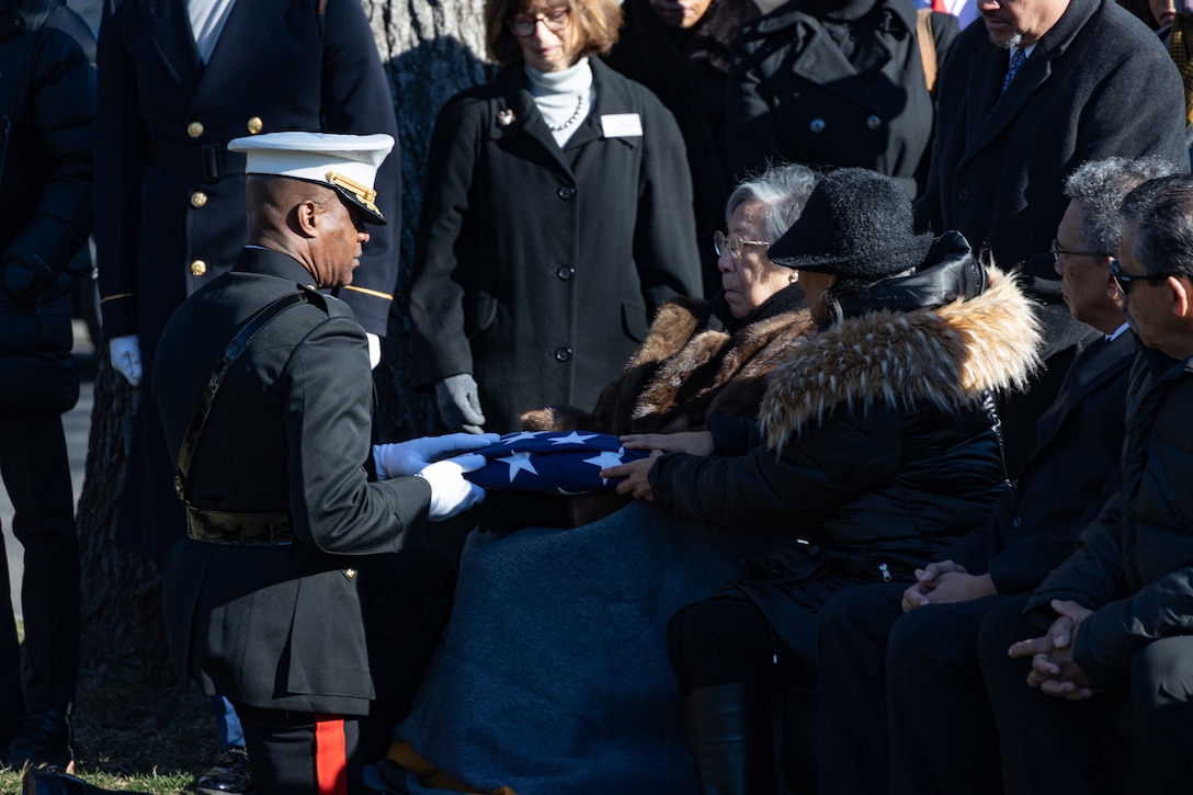 Brigadier Gen. Melvin G. Carter, deputy chief, Computer Network Operations, National Security Agency, presents the U.S. flag to Mable Bryant following the funeral service for her husband, U.S. Army Brig. Gen. Albert Bryant at Arlington National Cemetery, Arlington, Virginia, Feb. 5, 2024. Bryant began his military career at Montford Point, North Carolina, and earned the title Marine in 1943. While in the Marine Corps, Bryant served in World War II, including the battle of Iwo Jima. Following his enlistment in the Marine Corps, Bryant continued his military service in the U.S. Army Reserve, rising to the rank of brigadier general, the highest rank achieved by a Montford Point Marine. (U.S. Marine Corps photo by Lance Cpl. Joseph E. DeMarcus)