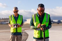Joven Cadiz, right, civil engineer technician, and Greg Murakami, left, airfield pavement inspection lead, Civil Engineering Branch, Naval Facilities Engineering Systems Command Pacific, inspect the taxiway area of Marine Corps Air Station Kaneohe Bay during an airfield inspection, Marine Corps Base Hawaii, Jan. 25, 2024. This inspection occurs every 3 years and serves to provide detailed information for the sustainment and maintenance of the airfield. (U.S. Marine Corps photo by Sgt. Brandon Aultman)