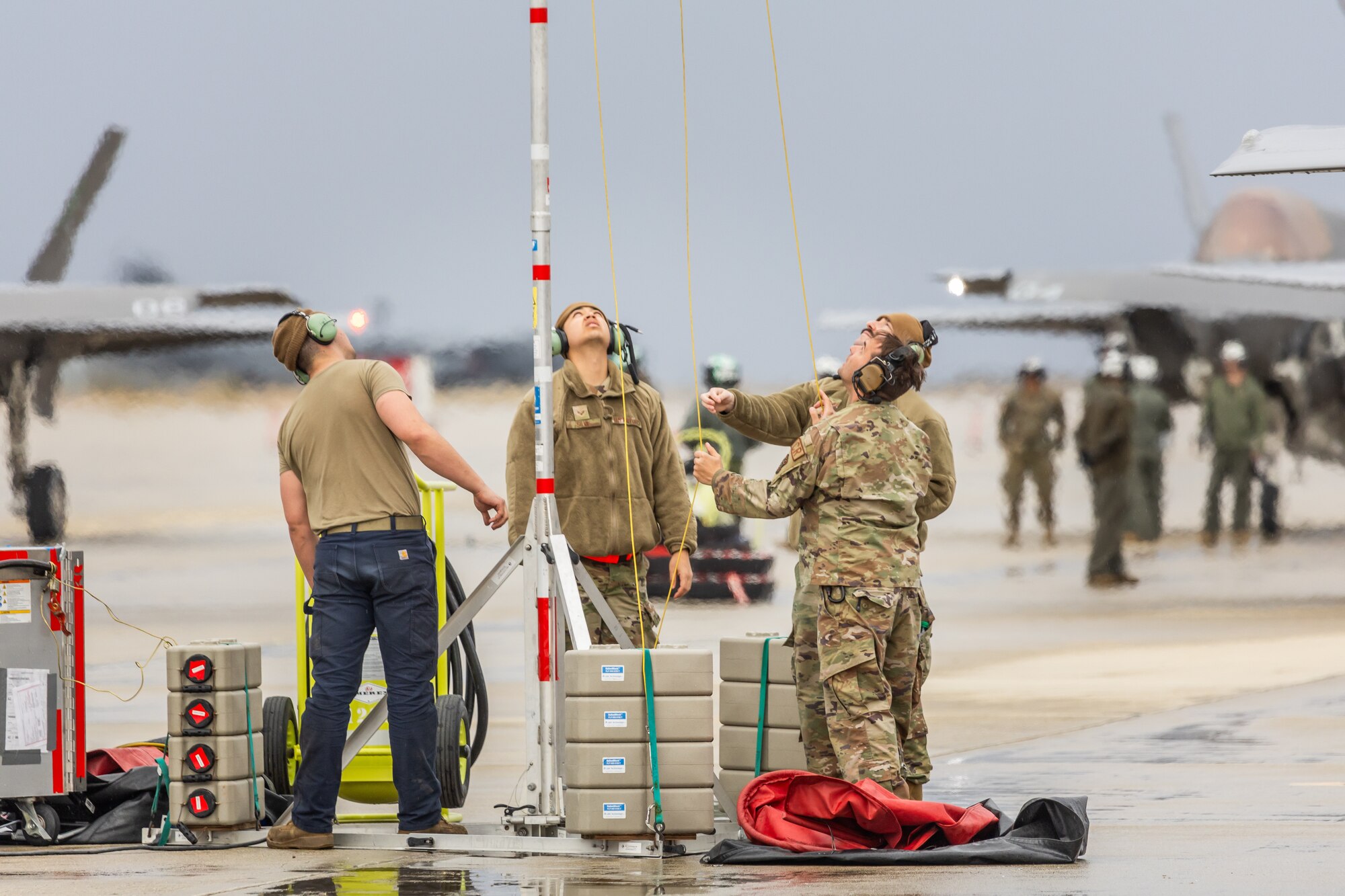 a photo of F-35 maintainers installing a lighting protection pole