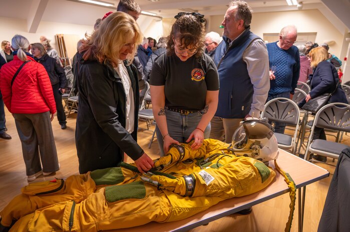 Members of the local community inspect a full-pressure suit.