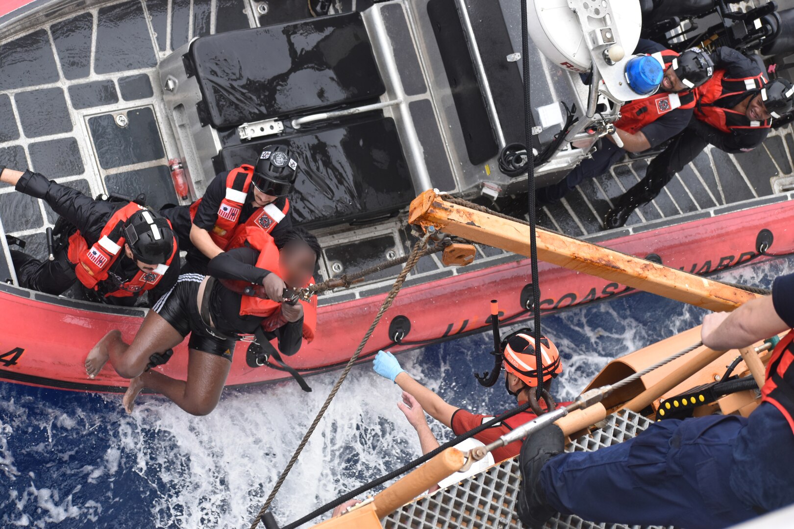 A Coast Guard Cutter Dependable (WMEC 626) small boat crew transfers a Haitian child to the cutter during a search and rescue mission in heavy seas, which resulted in the successful rescue of all 33 aboard a sinking vessel 6 miles off Haiti’s coast, Jan. 22, 2024. Dependable’s crew patrolled the Coast Guard Seventh District’s area of operations during a two-month deployment to conduct maritime law enforcement missions. (U.S. Coast Guard photo)