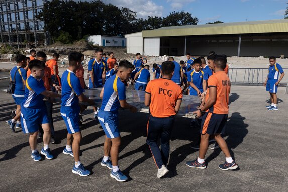 Philippine military and coast guard service members position pallets to secure Department of Social Welfare and Development family food packs in preparation for transportation at Villamor Airbase, Pasay City, Philippines, Feb. 11, 2024. At the request of the Government of the Philippines, the U.S. Marines of III Marine Expeditionary Force are supporting the U.S. Agency for International Development in providing foreign humanitarian assistance to the ongoing disaster relief mission in Mindanao. The forward presence and ready posture of III MEF assets in the region facilitated rapid and effective response to crisis, demonstrating the U.S.’s commitment to Allies and partners during times of need.  (U.S. Marine Corps photo by Sgt. Savannah Mesimer)