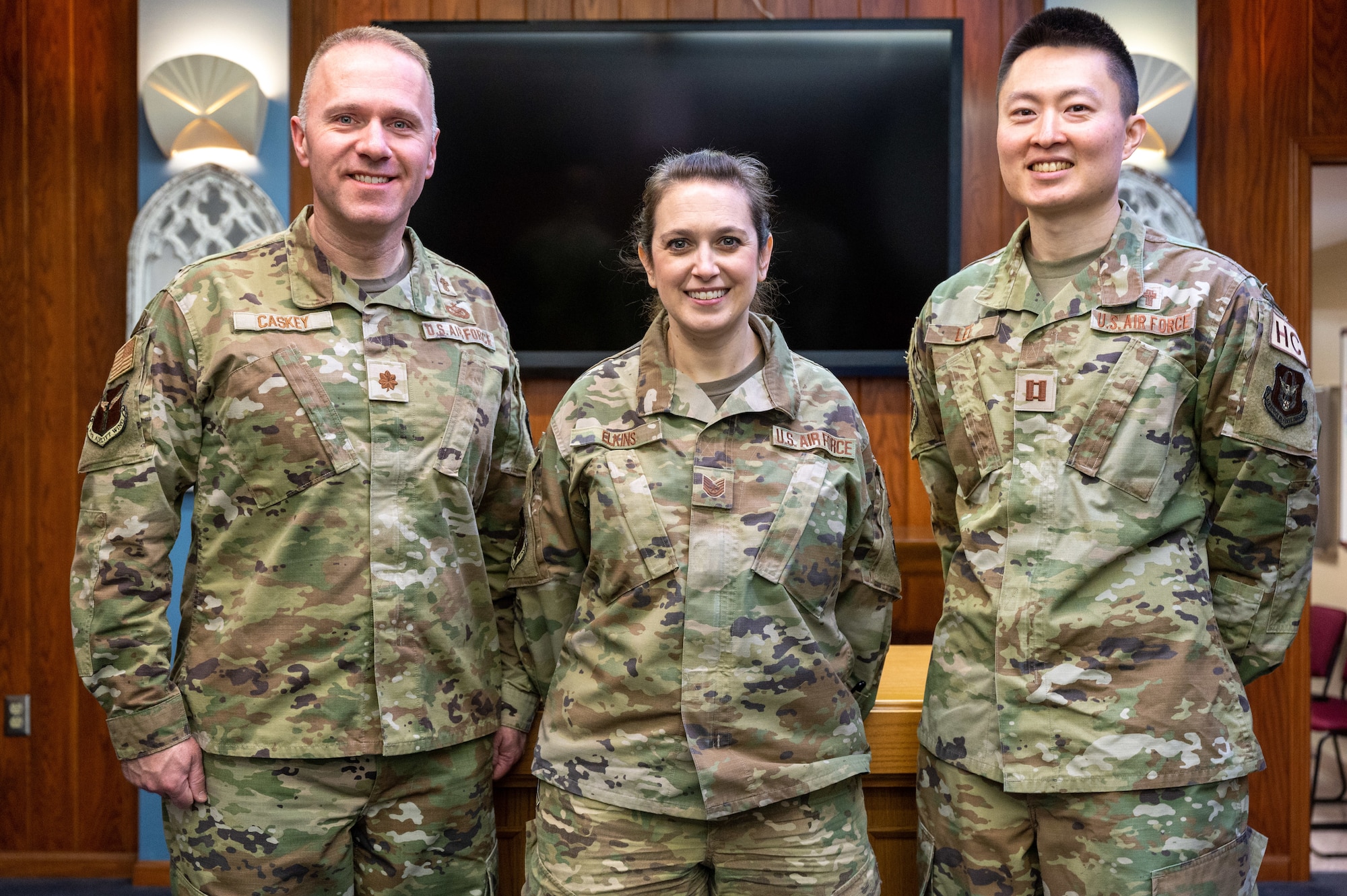 Maj. Jeremy Caskey, a 911th Airlift Wing chaplain, left, Capt. Jonathan Lee, a 911th chaplain, right, and Tech. Sgt. Amy Elkins, a 911th AW religious affairs Airman, pose for an informal group photo at the Pittsburgh International Airport Air Reserve Station chapel, Pennsylvania, Feb. 3, 2024. The U.S. Air Force and 911th Chaplain Corps team consist of a clergy of chaplain commissioned officers and enlisted RAAs. (U.S. Air Force photo by Staff Sgt. Timothy Leddick)