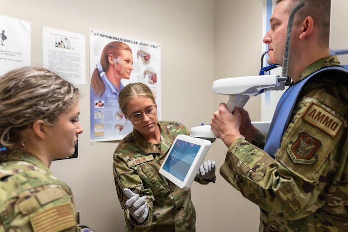 Airman Rilee Donahey, a 911th Aeromedical Staging Squadron dental assistant (left), and Tech. Sgt. Madeline Reeb, the 911th ASTS noncommissioned officer in charge of dental services, sets up a patient's x-ray at the Pittsburgh International Airport Air Reserve Station dental clinic, Pennsylvania, Feb. 3, 2024. A dental assistant's primary tasks include ensuring proper supplies are stocked, acquiring prescribed x-rays and set up and clean up of procedures.