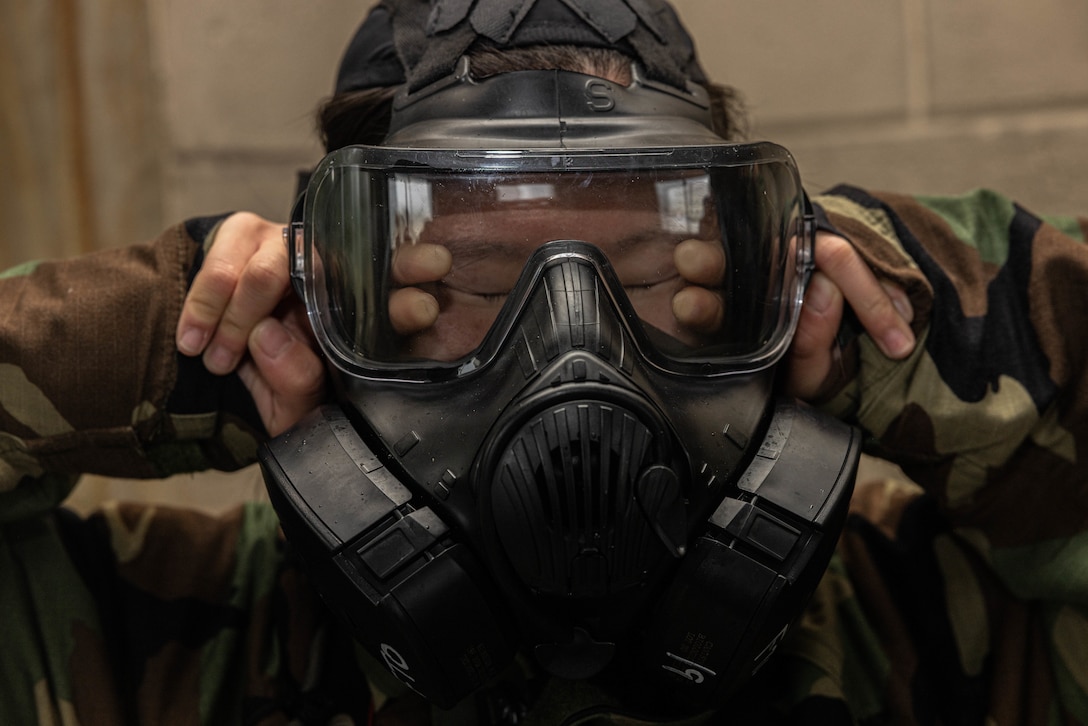 U.S. Marine Corps Cpl. Anna Geier, a combat videographer with 3rd Marine Division, III Marine Expeditionary Force, breaks the seal of her M50 joint service general purpose gas mask during a sensitive site exploitation exercise at Camp Courtney, Okinawa, Japan, Jan. 23, 2024. SETEX is a two-day training consisting of classroom study and practical application conducted to ensure Marines are prepared to acquire imagery in contaminated environments.
