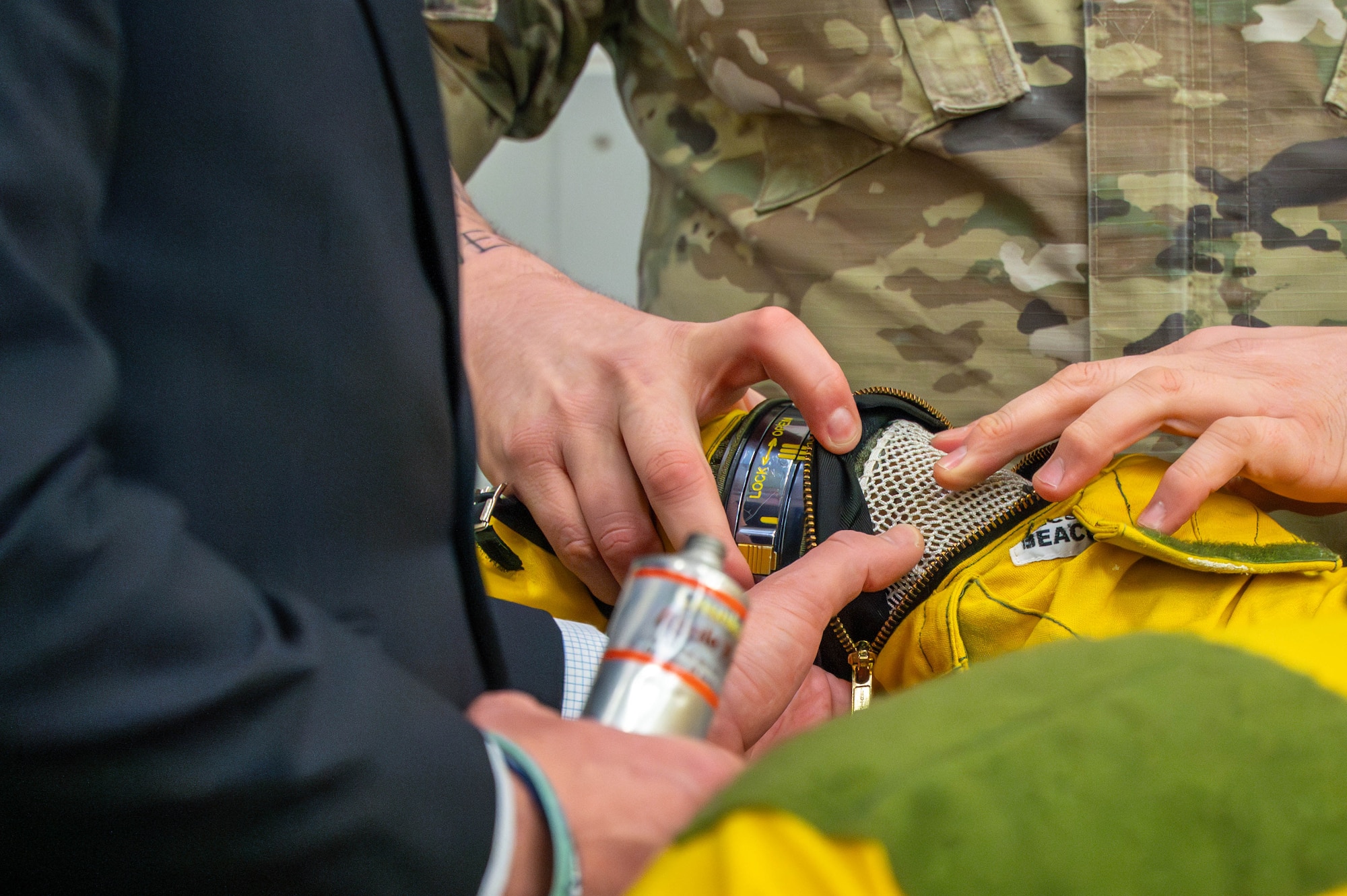 Hands touch and inspect the inner mesh lining of a U-2 pilot’s pressure suit