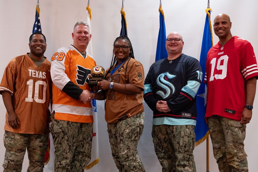 Senior leaders from Joint Base McGuire-Dix-Lakehurst, N.J., present an award to a U.S. Navy Sailor during the Annual Awards ceremony at JB MDL, Feb. 8, 2024. Members were recognized by JB MDL senior leaders for their exceptional performance throughout the year. (U.S. Air Force photo by Staff Sgt. Monica Roybal)