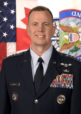 General Gregory M. Guillot biography photo with United States', Canadian, NORAD, and U.S. Northern Command flags behind him.