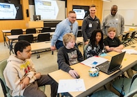 IMAGE: (Back row left to right) Naval Surface Warfare Center Dahlgren Division’s Jonathan Clark and Tyler Truslow and University of Mary Washington’s Dr. Michael Hubbard assist the King George Middle School team troubleshoot their robot during the Innovation Challenge @ Dahlgren: Middle School Robotics, Feb. 10.
