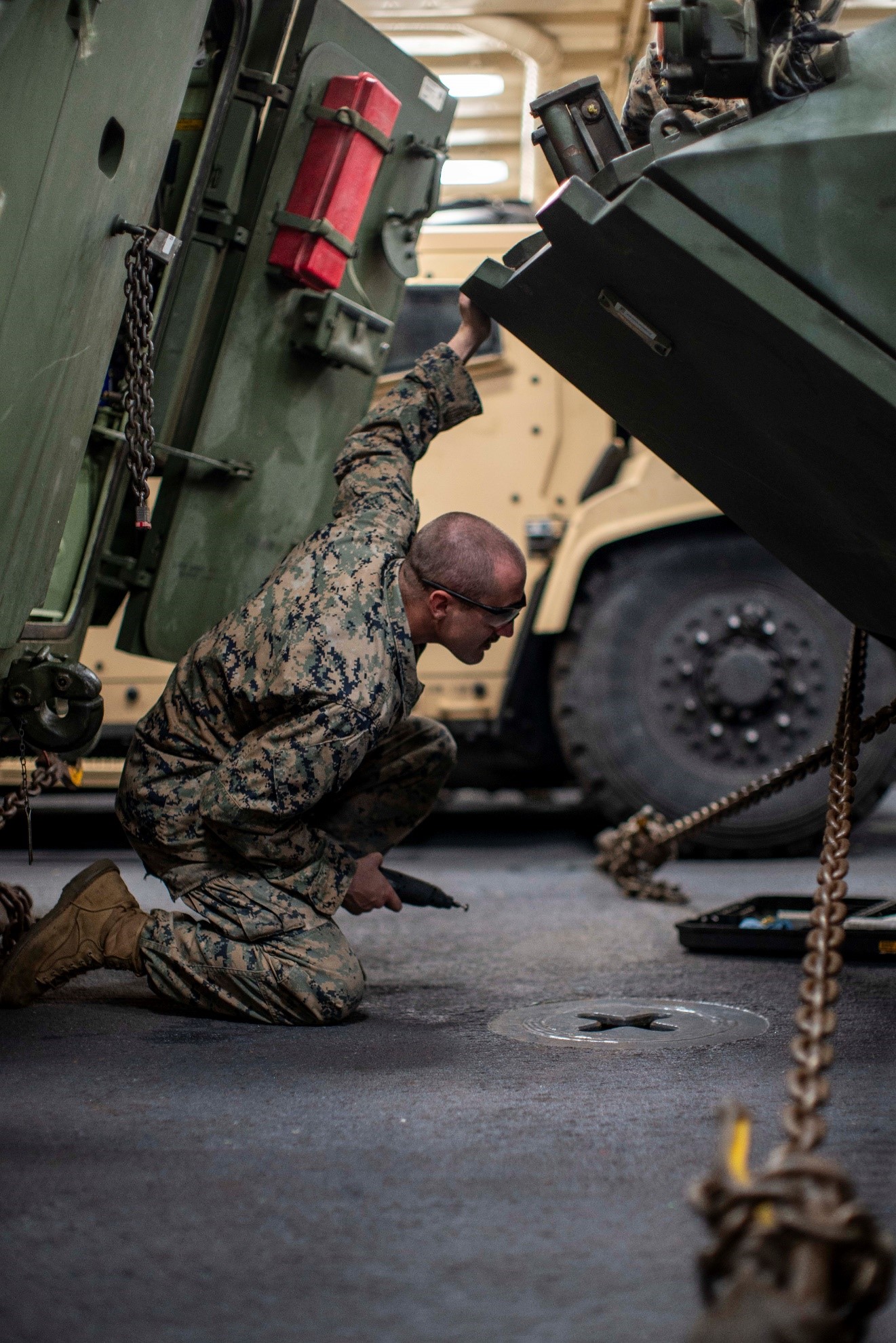 U.S. Marine Corps Cpl. Lucas Hough, a Light Armored Vehicle 25 gunner assigned to Light Armored Reconnaissance Company, Battalion Landing Team 1/5, 15th Marine Expeditionary Unit, and an Iowa native, inspects an LAV-25 for corrosion during routine vehicle maintenance aboard the amphibious transport dock USS Somerset (LPD 25) in the Pacific Ocean, Feb. 2, 2024