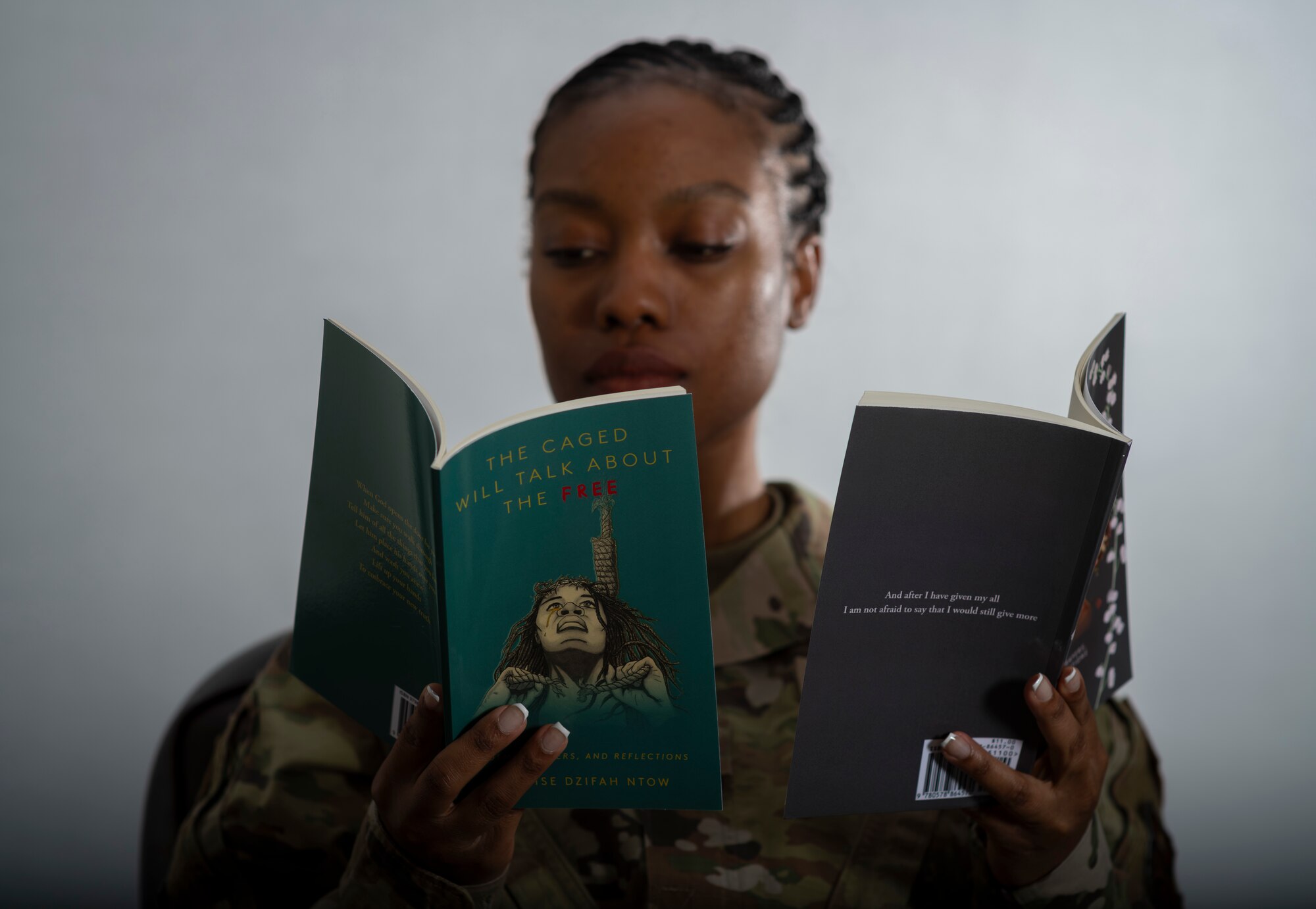 Airman poses for a photo holding books.
