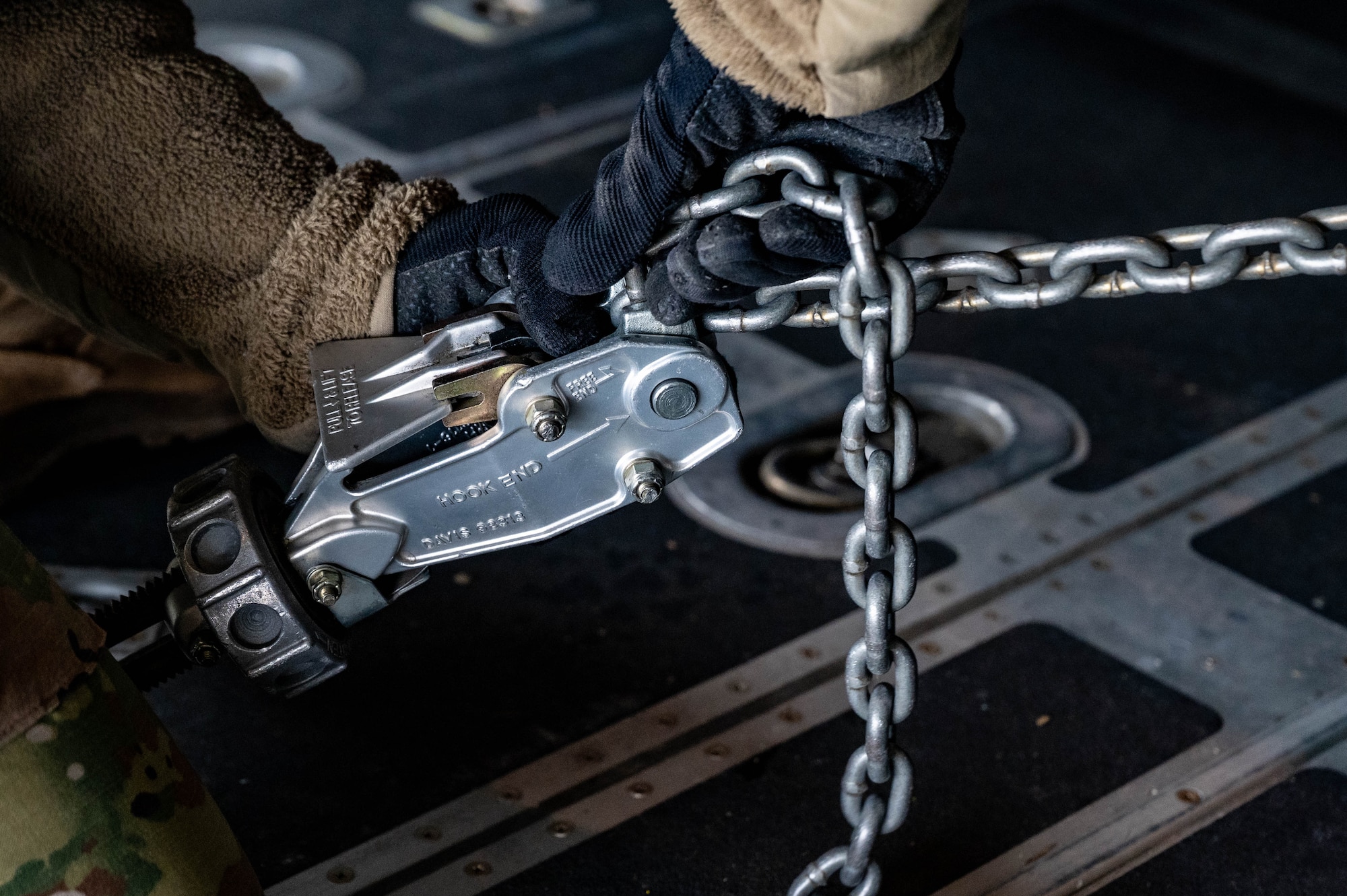 Staff Sgt. Angeliya Tango, 32nd Aerial Port Squadron air transportation specialist, attaches a chain to a cargo tiedown inside a C-130H Hercules at Youngstown Air Reserve Station, Ohio, Jan. 6, 2024. Tango secured a High Mobility Multipurpose Wheeled Vehicle, known as a Humvee, in the back of the aircraft during engine running onload/offload training. (U.S. Air Force photo by Tech. Sgt. Lucas M. Weber)