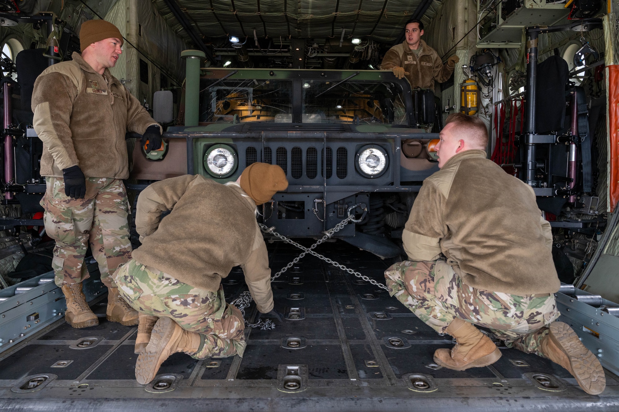 Members the 32nd Aerial Port Squadron secure a High Mobility Multipurpose Wheeled Vehicle, or Humvee, inside a C-130H Hercules at Youngstown Air Reserve Station, Ohio, Jan. 6, 2024. The Humvee weighs approximately 5,000 pounds and securing it was crucial training for the Airmen as they prepared for the 2024 Port Dawg Challenge. (U.S. Air Force photo by Tech. Sgt. Lucas M. Weber)