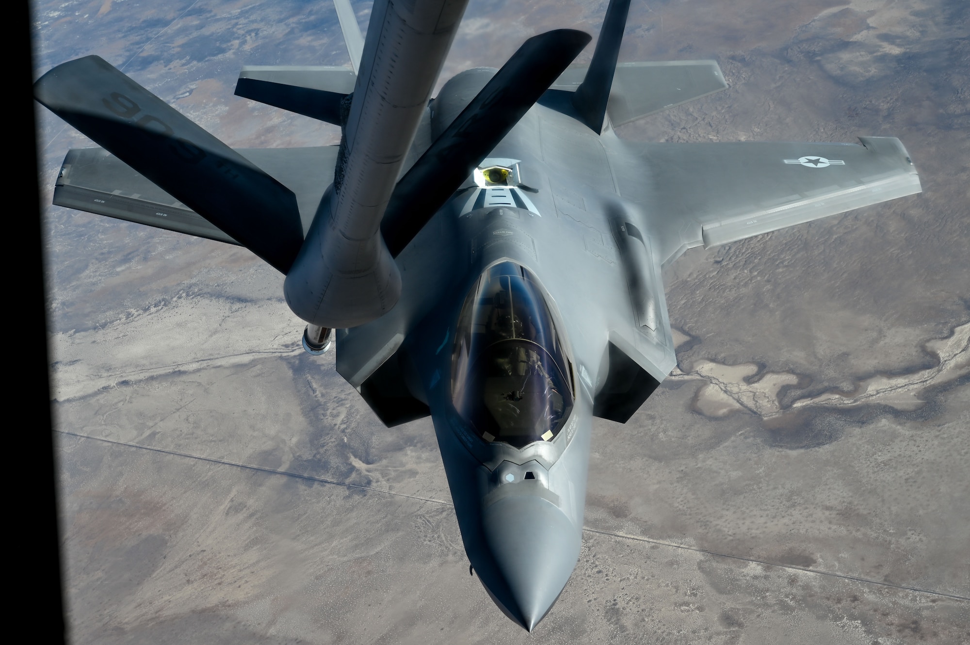 An F-35A Lightning II approaches to receive fuel from a KC-135 Stratotankers assigned to the 92nd Air Refueling Wing during the Weapons Integration course over the Nevada Test and Training Range, Dec. 11, 2023. Air refueling crews assigned to the 92nd, 93rd and 97th Air Refueling Squadrons at Fairchild Air Force Base, Washington, participated in the WSINT course to enhance interoperability with a variety of aircraft and demonstrate how Air Mobility Command’s air refueling capabilities enhance global reach for all Department of Defense air operations. WSINT is a series of complex, large-force employment missions that serve as the capstone portion of Weapons School classes, which take place twice a year at Nellis Air Force Base, Nevada. WSINT students plan and execute every aspect of air, space and cyber combat operations, with joint force components converging over the Nevada Test and Training Range. (U.S. Air Force photo by Senior Airman Haiden Morris)