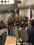 group of men and women wearing u.s. army uniforms standing in front of an audience.