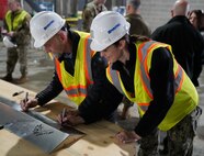 Lt. Sharadan Rorabaugh, assistant resident officer in charge of construction and David Wolfel (left), acting program and project management director signed the truss during Joint Base Andrews topping out ceremony held Jan. 10.