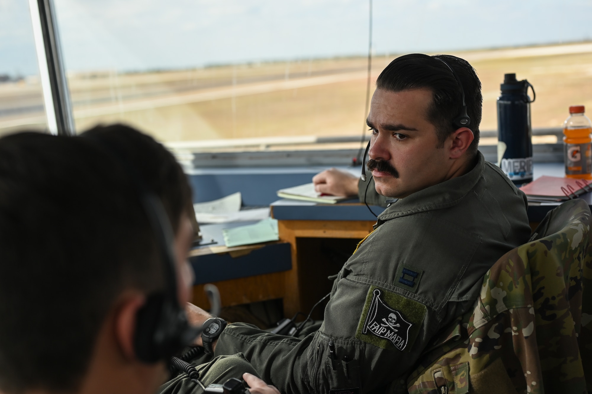 U.S. Air Force Capt. Randy Williams, 85th Flying Training Squadron first assignment instructor pilot, listens to a colleague in the runway supervisory unit (RSU) at Laughlin Air Force Base, Texas, Dec. 7, 2023.