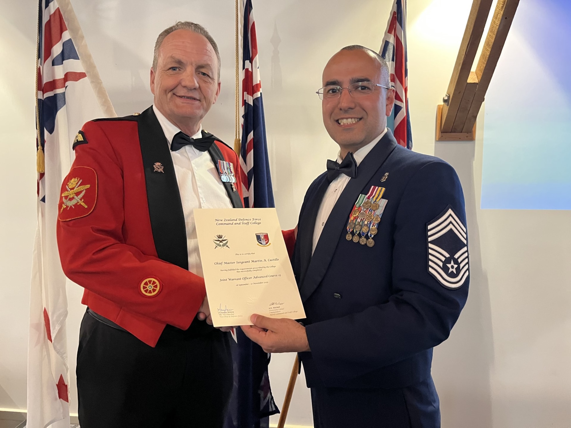 U.S. Air Force Chief Master Sgt. Martin Castillo (right) with the 673rd Medical Group, poses with Warrant Officer Class One Mark Mortiboy, Warrant Officer of the Defence Force (left) after completing New Zealand Defence Force Joint Warrant Officer Advance Course at the NZDF College Nov. 18, 2023. The academically rigorous course included visits to Hawaii’s U.S.'s Indo-Pacific Command and Asia-Pacific Center for Security Studies, and New Caledonia, a French territory in the southwest Pacific, to better understand Indo-Pacific concerns.