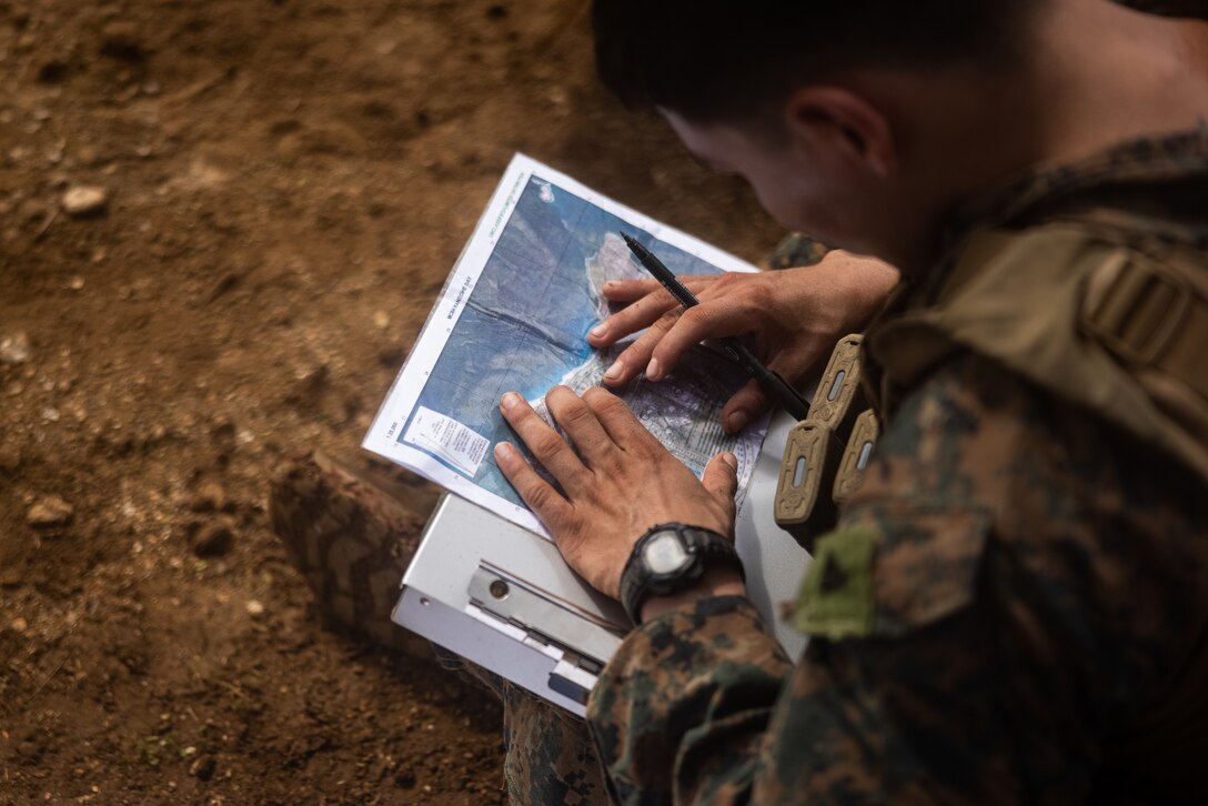 U.S. Marine Corps Cpl. Joshua Vega conducts call for fire transmissions during an annual squad competition at Marine Corps Base Hawaii, Nov. 28, 2023.  The competition was designed to test the Marines’ physical fitness levels, improve tactical proficiency, and build unit cohesion. Vega is an infantryman with 3d Littoral Combat Team, 3d Marine Littoral Regiment, 3d Marine Division, and a California native. (U.S. Marine Corps photo by Cpl. Malia Sparks)