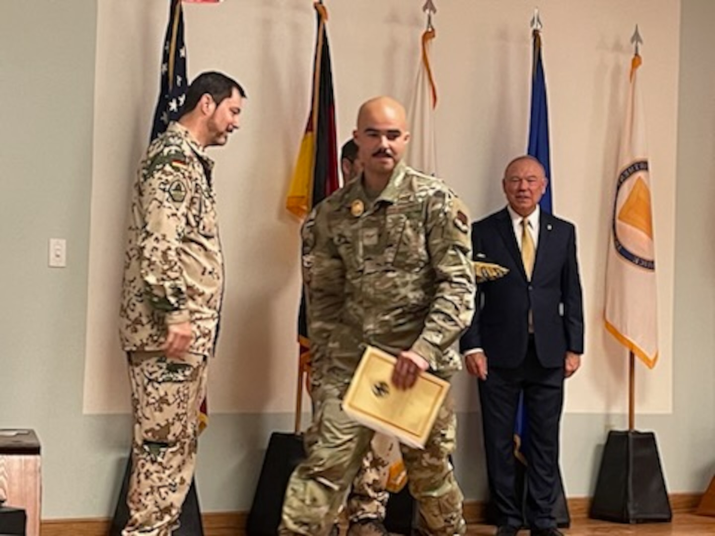 An Airman walks off the stage after receiving his German Armed Forces Proficiency Badge certificate.