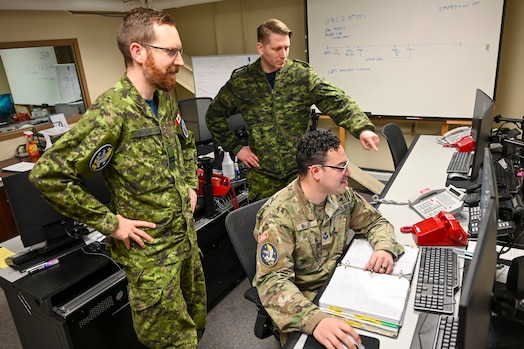  Royal Canadian Air Force Capt. Alex Willison, left, 7th Space Warning Squadron (7 SWS) commander in charge, Royal Canadian Air Force Sgt. Kristjan Lindvere, 7 SWS SNCO in charge of training, and U.S. Space Force Sgt. Dustin Wallis, 7 SWS deputy staff instructor, goes through a training simulation for the Upgraded Early Warning Radar (UEWR) on Beale Air Force Base, California, Feb. 8, 2024.