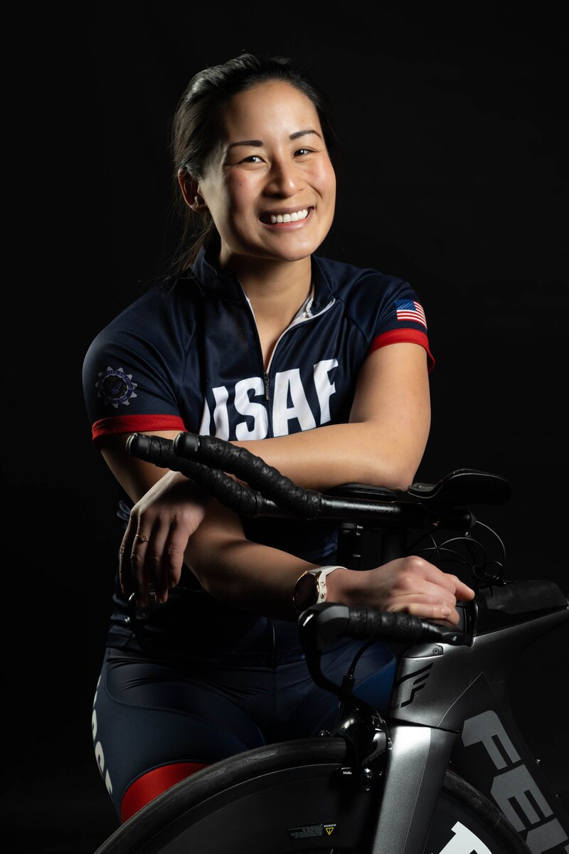 Smith with her bike in a studio smiling at the camera