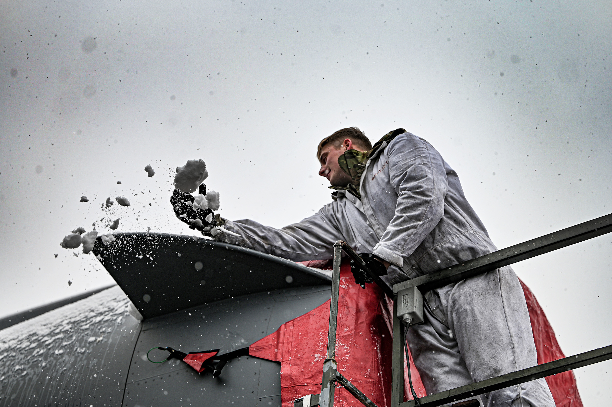 Senior Airman Killian Sullivan, 445th Aircraft Maintenance Squadron aircraft mechanic, clears
snow as he installs an engine cover on a C-17 Globemaster III at Wright-Patterson AFB, Ohio, Jan. 6, 2024. (U.S. Air Force photo/Master Sgt. Patrick O’Reilly)