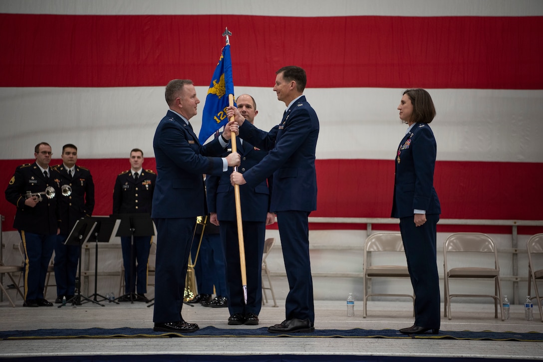 Brig. Gen. David May, Adjutant General for Air, Wisconsin National Guard, passes the wing guidon to Col. Charles Merkel as he takes command of the 128th Air Refueling Wing, here at Milwaukee Mitchell Airfield, Feb. 3, 2024. The passing of colors from an outgoing commander to an incoming one ensures the unit and its Airmen are never without official leadership, a continuation of trust. (U.S. Air National Guard photo by Airman 1st Class Cynthia Yang)